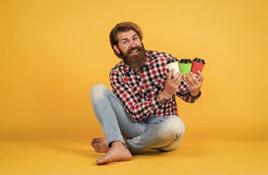 Mutlu, sakallı, sakalsız, şık saçlı, sıradan kıyafetler giyen, kahve içen, barista