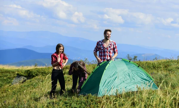 Teamwork concept. Hiking activity. Group friends set up tent on top mountain. Helpful to have partner for raising tent. Camping hiking. Almost done. Attach necessary structural components tent — Stock Fotó