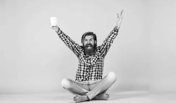 Heureux beau barbu gars avec visage non rasé et coiffure élégante porter des vêtements décontractés boire du café, succès — Photo