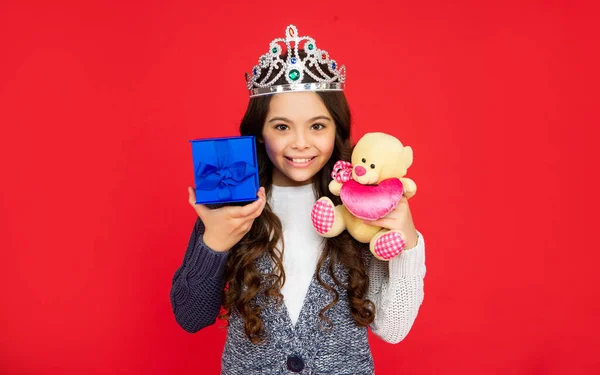 Cheerful child in queen crown. princess in tiara hold box. kid with present. — Photo