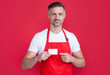Üzerinde fotokopi alanı olan önlüklü olgun bir adam. işaret parmağı