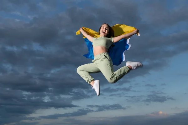 Feliz adolescente menina salto com bandeira nacional ucraniana da Ucrânia, felicidade e liberdade — Fotografia de Stock