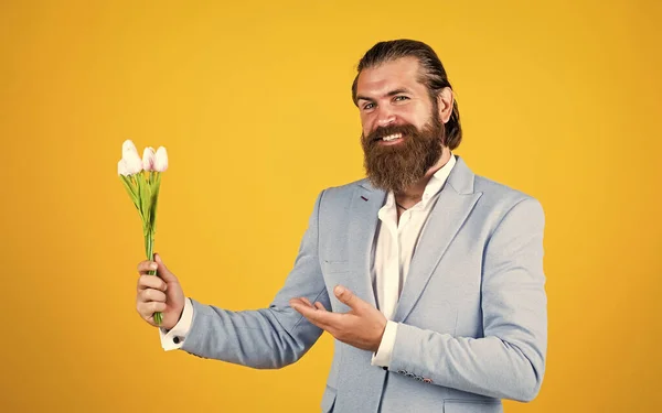 Le jour du mariage. heureux jour des pères. marié marié mature avec bouquet. Un hipster tient des fleurs de tulipes. cadeau pour rendez-vous romantique. homme barbu dans une veste élégante tenir des fleurs. C'est pour elle. — Photo