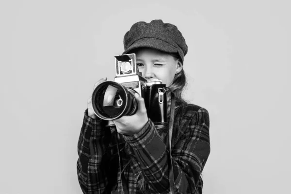 Tiener meisje met retro foto camera dragen trendy hoed en geruite jas, vintage fotografie — Stockfoto