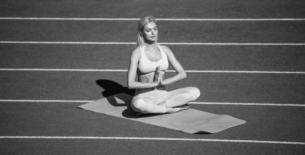 女运动员穿着健美服，在体育场练瑜伽，冥想 — 图库照片