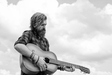 Sakallı ve bıyıklı adam gitar çalıyor. Kareli gömlekli sakallı adam şarkı söylüyor. Müzisyen müzisyen. müzik teli enstrümanı. Olgun karizmatik erkek gitarist