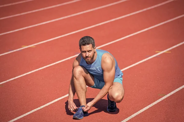Sport man stropdas veters na training, gezonde levensstijl — Stockfoto