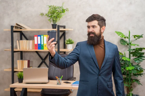 Felice uomo d'affari barbuto bere caffè da asporto in ufficio con spazio copia, take away — Foto Stock