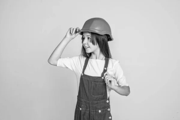 Девочка в форме и шлеме во время работы в мастерской, успех — стоковое фото