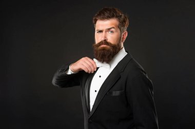 Smokin papyonlu ciddi bir adam. Siyah arka planda resmi giyinen bir adam. erkek resmi moda