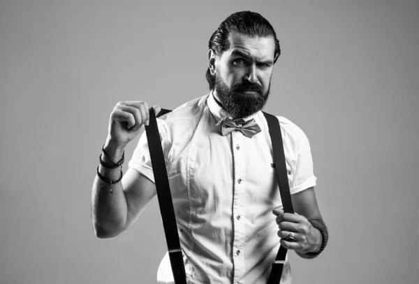 Взрослый бородатый мужчина хипстер с усами носить подтяжки и галстук-бабочка, винтажный вид моды — стоковое фото
