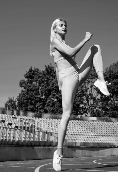 Kadın kaslı vücutla ısınıyor güneşli bir gün, atletik — Stok fotoğraf
