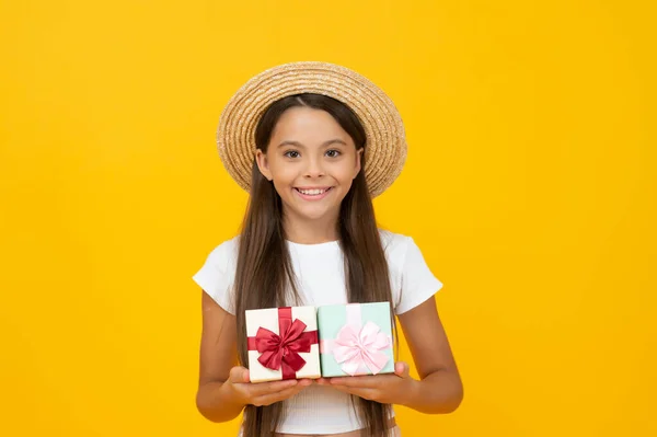 Счастливый ребенок-подросток держит подарок коробку на желтом фоне — стоковое фото