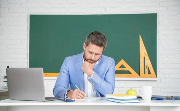 Školní učitel ve třídě s notebookem na tabuli — Stock fotografie