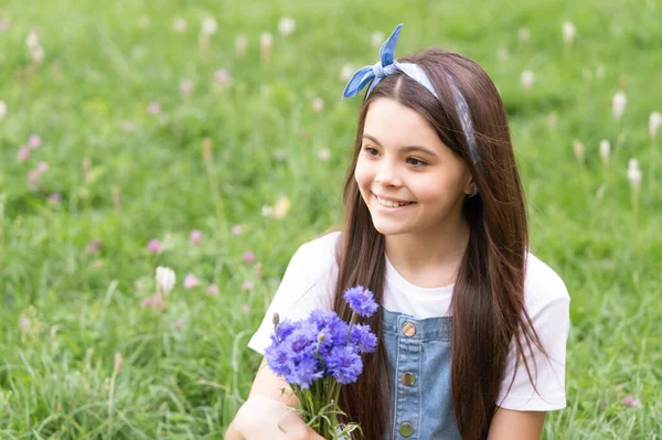 Menina feliz na grama com flores da primavera. espaço de cópia — Fotografia de Stock