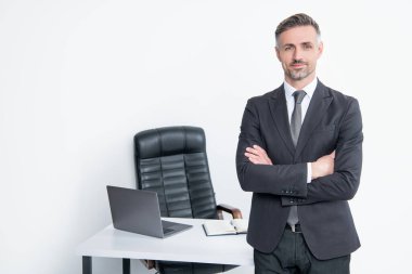 Yetişkin girişimci beyaz arka planda patron ofisinde takım elbise giyer.