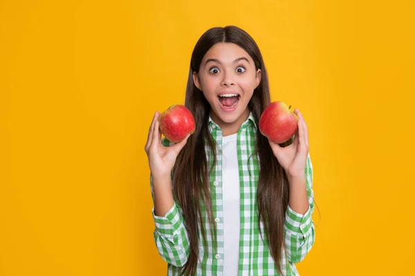 Niño sorprendido con manzana fresca sobre fondo amarillo — Foto de Stock