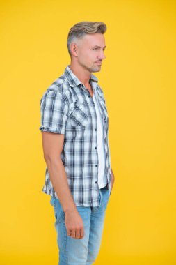 Sarı arka planda kır saçlı olgun bir adam.