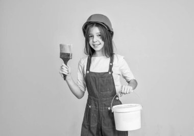 İş bittikten sonra. Miğferli kız müteahhitlik yapıyor. İnşaat ve yenileme. Çocuk inşaat yapıyor. Mühendis genç inşaat işçisi. Uluslararası İşçi Günü. ressam çalışma araçlarını kullanır