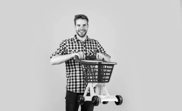 Dia de compras bem sucedido. Comprador masculino com carrinho de compras. O tipo barbudo de camisa quadriculada compra. homem bonito sem barba com cerdas. comprar produtos no shopping. deveres cotidianos e rotina — Fotografia de Stock