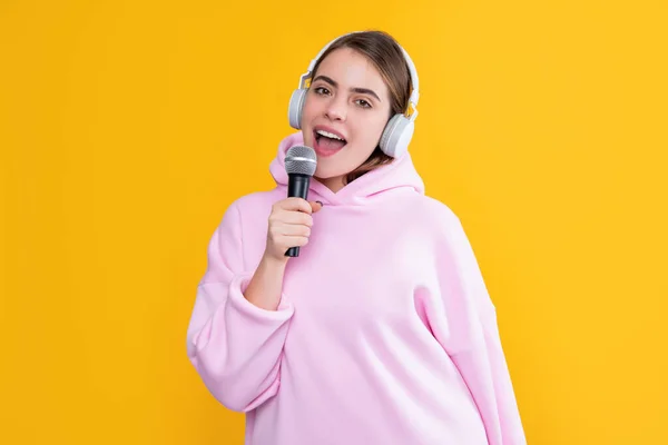 Τραγουδίστρια κορίτσι σε ακουστικά με μικρόφωνο σε κίτρινο φόντο — Φωτογραφία Αρχείου