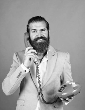 happy man with retro phone. brutal bearded man hold vintage telephone. concept of technology in modern life. communication. idea of conversation. man speak on phone