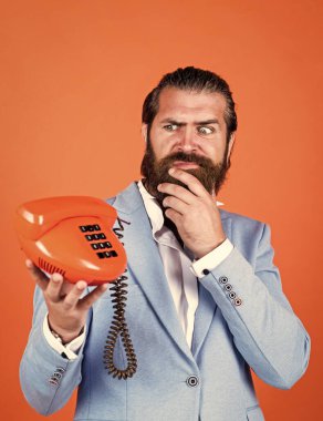 Modern ve klasik teknoloji. Sakallı hippi retro telefon kullanıyor. İletişim konsepti. Bıyıklı vahşi yakışıklı adam telefonda konuşuyor. Ara ve konuş