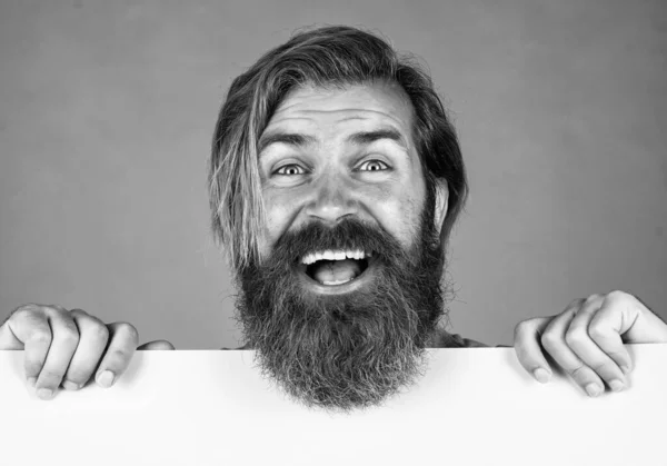 Pleasant smile. barbershop and hairdresser. male beauty and fashion. happy bearded man. brutal caucasian hipster hold paper shit, copy space. human emotions. unshaven guy with groomed long hair — Foto de Stock