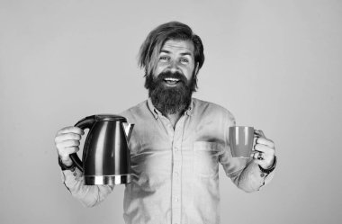 İçelim. Sakallı, çay içen olgun bir hippi. Elektrikli su ısıtıcısı olan vahşi bir adam. Gününü ısıt. Sakallı adam. Sıcak içecek iç. Mutfak gereçlerini sunuyorum. iyi kalite.