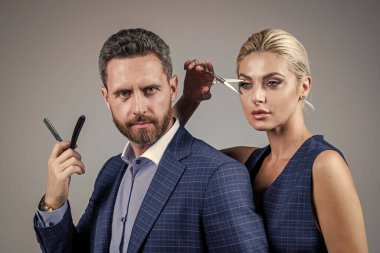 Bir çift zarif kuaför. Profesyonel berber çifti. Makas tutan iş adamı ve seksi bayan. Yakışıklı adam ve kadın jilet kullanır. Moda. Berber aletleri. kuaförlük.