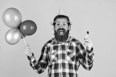 Havalı saç stili olan şık sakallı adam kareli gömlek giyiyor parti balonları tutuyor, eğleniyor..