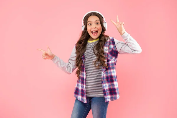 Sorprendida Chica Adolescente Con Auriculares Señalando Dedo Sobre Fondo Rosa —  Fotos de Stock