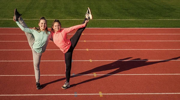 Ginastas Adolescentes Felizes Fazem Divisões Verticais Segurando Pernas Pista Atletismo — Fotografia de Stock
