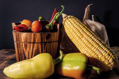 Biber ve domatesli taze mısır koçanı. Organik sebzeler. Tahta kovada doğal yiyecekler..