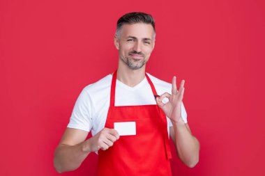 Üzerinde fotokopi alanı olan önlüklü neşeli, olgun bir adam. Tamam.