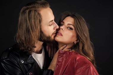 Erkeğe ve kadına aşık şık bir çift deri ceket giyer, öpüşürler..