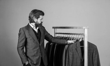 Özel dikim takım elbiseli bir adam pahalı bir smokin giyiyor. Butikte erkek kıyafetleri. Takım elbiseli adam. Atölyesindeki terzi. Klasik kostümlü yakışıklı sakallı moda adamı..