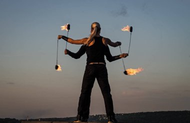 Şehvetli dansçılar ateş performansı sergilerler. Yanan mavi gökyüzü, sıcak..