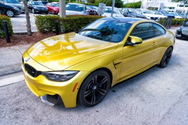 Miami Beach, Florida USA - 15 Nisan 2021: Sarı bmw m4, köşe başı manzaralı. Lüks spor araba..