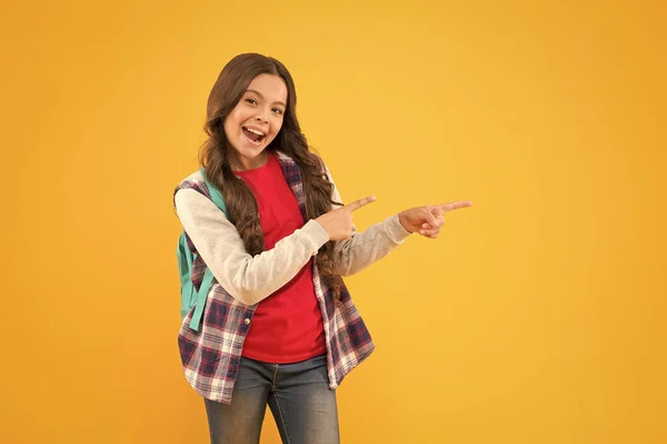 これを見て 幸せな十代の女の子のポイントの指黄色の背景 ジェスチャーを指差す 広告のためのポイント 手のジェスチャー 基礎教育 学校に戻り スペースをコピーします — ストック写真