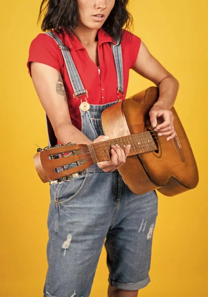 musical shop. country music style. attractive beauty with acoustic guitar. musical string instrument. female singer sing a song. happy woman play the guitar. girl guitarist in shirt and jeans.