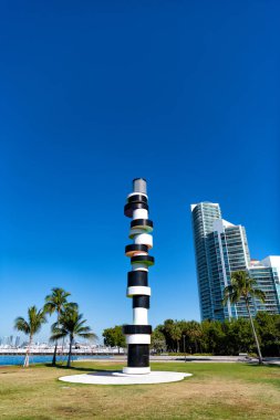 South Pointe park rıhtımında deniz feneri heykeli ve South Beach, ABD 'de mavi gökyüzünde gökdelenler.