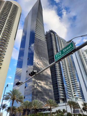Sunny Isles, ABD 'nin şehir caddesinde bulutlu gökyüzünde yükselen yükselticiler.