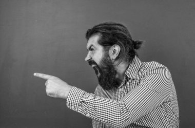 Sakallı ve bıyıklı öfkeli bir adam okuldaki ya da okuldaki iş adamı ya da öğretmen gibi görünüyor. Öfke..