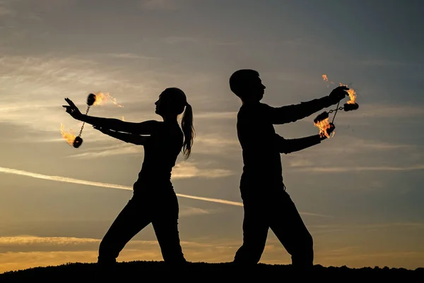男と女のカップルは 屋外の牧歌的な夜空に暗いシルエットで火のパフォーマンス中に燃焼ポイダンスを実行します 燃えるような — ストック写真