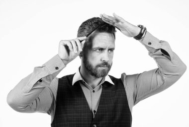 Kuaför konsepti. Olgun profesyonel berber tarak. Saç fırçasıyla saç tarayan yakışıklı bir kuaför. Berber dükkanı. Kendine güvenen adam tımar ediyor. Erkek güzelliği ve moda.