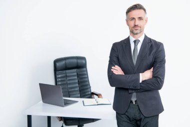 Olgun adam patron ofisinde beyaz arka planda takım elbise giyer..
