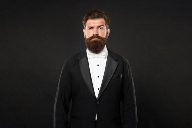 Smokin papyonlu ciddi bir adam. Siyah arka planda resmi giyinen bir adam. erkek resmi moda.