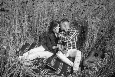 Gitarlı aşıklar çiçek tarlasında şarap içerler. Müzik. Birbirine aşık çiftler. Haşhaş tarlasında bir adam ve kadın. Yaz çiçeği çayırı. Gelincikler arasında romantik bir çift. Aşk ve romantizm. Afyon. bahar kırsal.