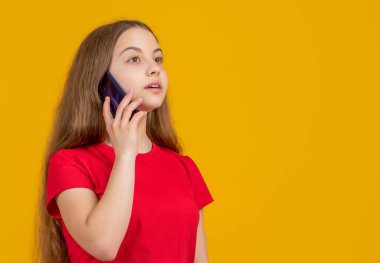 Çocuk sarı arka planda akıllı telefondan konuşuyor..